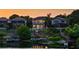Waterfront homes with private docks are beautifully lit at dusk, reflecting in the calm lake at 8125 Via Rosa, Orlando, FL 32836