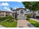 Beautiful two-story home boasts a lush front yard with palm trees and a brick driveway at 8125 Via Rosa, Orlando, FL 32836