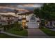 Stunning two-story home with well-manicured landscaping and a paver driveway at dusk at 8125 Via Rosa, Orlando, FL 32836
