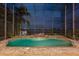 Relaxing screened-in pool with spill-over spa with waterfront views at night at 8125 Via Rosa, Orlando, FL 32836