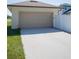 A two-car garage with a wide driveway and adjacent white fence at 900 S Maple Ave, Sanford, FL 32771