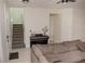 Inviting living room featuring a comfortable sofa, piano, and staircase at 900 S Maple Ave, Sanford, FL 32771