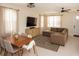 Bright living room featuring a comfortable sectional sofa, large TV, and elegant dining set at 900 S Maple Ave, Sanford, FL 32771