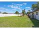 A spacious, well-maintained backyard with a wooden pergola and pristine white fence at 1148 Martin L King Dr, Orlando, FL 32805