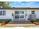 Covered backyard patio with sliding glass doors, modern potted plants, and colorful landscaping at 1148 Martin L King Dr, Orlando, FL 32805