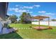Expansive backyard featuring a wooden pergola, lush lawn, and manicured landscaping at 1148 Martin L King Dr, Orlando, FL 32805