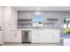 Bright kitchenette featuring modern appliances, floating shelves, and quartz countertops at 1148 Martin L King Dr, Orlando, FL 32805