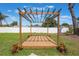 Backyard features a wooden pergola on a lush green lawn with landscaping at 1148 Martin L King Dr, Orlando, FL 32805