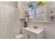 Bright bathroom with a white vanity, frosted window, and a shower with curtain at 12 N Forest Ave, Orlando, FL 32803