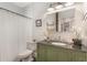 Bathroom featuring an olive green vanity, black countertop, decorative mirror and shower at 12 N Forest Ave, Orlando, FL 32803