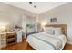 Well-lit bedroom with wooden floors, a comfy bed, and a decorative writing desk at 12 N Forest Ave, Orlando, FL 32803