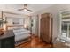 Bedroom with canopy bed, wooden floors, stylish wardrobe, and natural lighting at 12 N Forest Ave, Orlando, FL 32803