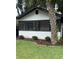 Charming home with a screened-in porch, landscaped yard, and mature palm tree at 12 N Forest Ave, Orlando, FL 32803