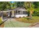 Charming bungalow featuring a carport, screened porch, and attractive landscaping at 12 N Forest Ave, Orlando, FL 32803