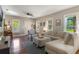 Bright and airy living room featuring hardwood floors, a large sectional sofa, and a piano at 12 N Forest Ave, Orlando, FL 32803