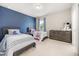 This bedroom has two twin beds and a blue accent wall to create a fun and cozy atmosphere at 12173 Aztec Rose Ln, Orlando, FL 32827