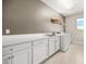 This laundry room has white cabinets, counter space, a sink, and a washer and dryer at 12173 Aztec Rose Ln, Orlando, FL 32827