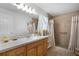 Bathroom with vanity, walk-in shower, tile flooring, large mirror and sheer curtains at 13234 Moonflower Ct, Clermont, FL 34711