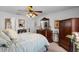 A bedroom with hardwood furniture, a light blue bedspread, and a ceiling fan with lighting at 13234 Moonflower Ct, Clermont, FL 34711