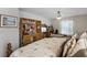 Well-lit bedroom with a large bookcase, cozy fireplace, and ceiling fan at 13234 Moonflower Ct, Clermont, FL 34711