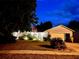 Night view of the home featuring landscaped front yard, a driveway, and a two-car garage at 13234 Moonflower Ct, Clermont, FL 34711