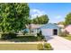 Charming single-Gathering home featuring a lush green lawn, mature trees, and a two-car garage at 13234 Moonflower Ct, Clermont, FL 34711