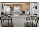 Bright kitchen area with stainless steel appliances, wooden cabinets, breakfast bar, and two chairs for seating at 13234 Moonflower Ct, Clermont, FL 34711