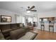 Inviting living room features a plush sectional sofa, ceiling fan, and an open view to the dining area and kitchen at 13234 Moonflower Ct, Clermont, FL 34711