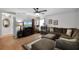 Cozy living room with hardwood floors, large sectional, and a ceiling fan, perfect for relaxation and entertainment at 13234 Moonflower Ct, Clermont, FL 34711