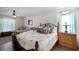 Comfortable main bedroom suite with a decorative headboard, ceiling fan, and bright natural light at 13234 Moonflower Ct, Clermont, FL 34711