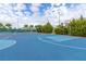 Well-maintained basketball court with colorful surfaces, surrounded by lush greenery and lighting at 13247 Hatherton Cir, Orlando, FL 32832