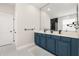 Elegant bathroom featuring a blue vanity, double sinks, and a large mirror at 13247 Hatherton Cir, Orlando, FL 32832