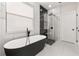 Modern bathroom featuring a freestanding tub, glass-enclosed shower, and sleek black and white design at 13247 Hatherton Cir, Orlando, FL 32832