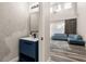 Modern bathroom with a stylish vanity, textured walls, and a glimpse of a cozy living area at 13247 Hatherton Cir, Orlando, FL 32832
