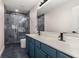 Bathroom with blue double vanity and glass enclosed shower with dark accent tile at 13247 Hatherton Cir, Orlando, FL 32832