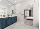 Bright bathroom with double vanity, blue cabinets, and an open doorway to the bedroom at 13247 Hatherton Cir, Orlando, FL 32832