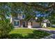 Inviting home front with a stone facade, an attached two-car garage, and lush green lawn at 13247 Hatherton Cir, Orlando, FL 32832