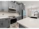 Charming kitchen with gray cabinetry, stainless appliances, and a bright white quartz countertop at 13247 Hatherton Cir, Orlando, FL 32832