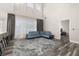 Sun-filled living room with high ceilings, stylish light fixture, and comfortable blue sofa at 13247 Hatherton Cir, Orlando, FL 32832