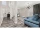 Open-concept living room with high ceilings, stylish light fixture, and comfortable blue sofa at 13247 Hatherton Cir, Orlando, FL 32832