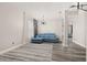 Bright living room featuring gray wood floors, stylish light fixture and comfortable blue sofa at 13247 Hatherton Cir, Orlando, FL 32832