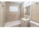 Updated bathroom includes tiled shower, tub, modern vanity, and large mirror at 1411 N Powers Dr, Orlando, FL 32818