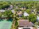 Aerial view of neighborhood and home with mature trees, green space and a tennis court nearby at 1450 Harbour Dr, Longwood, FL 32750