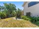 Landscaped backyard with mature trees and stone patio on a sunny day at 1450 Harbour Dr, Longwood, FL 32750