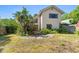 View of the backyard of this multi-story home with a stone patio and privacy landscaping at 1450 Harbour Dr, Longwood, FL 32750