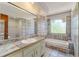 Bathroom with large mirror, patterned tile, soaking tub and shower combo at 1450 Harbour Dr, Longwood, FL 32750