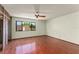 A spacious bedroom with hardwood floors, ceiling fan, and a closet with folding doors and view to the yard at 1450 Harbour Dr, Longwood, FL 32750