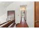 Upstairs hallway featuring hardwood floors, leading to various rooms, and a view of the downstairs area at 1450 Harbour Dr, Longwood, FL 32750