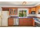 Kitchen with stainless steel appliances, wood cabinets, tile countertops, and bright natural light at 1450 Harbour Dr, Longwood, FL 32750
