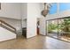 Bright living room with staircase, beautiful tiled floors and views of the landscaped outdoor area at 1450 Harbour Dr, Longwood, FL 32750